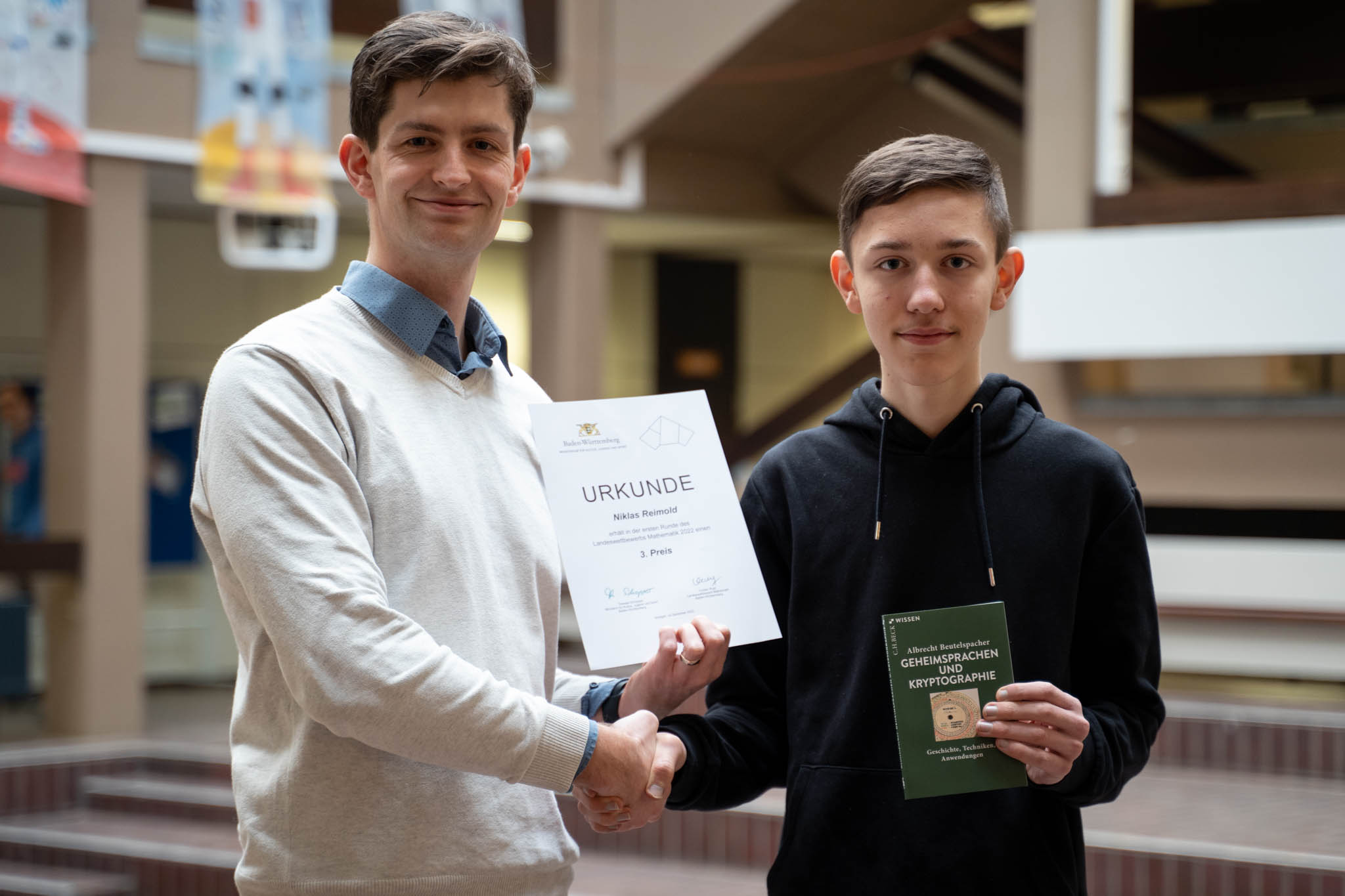 Mathematiklehrer Alexander Berchtold gratuliert Niklas Reimold zu seinem Erfolg beim Landeswettbewerb Mathematik.